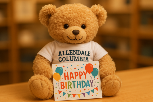 teddy bear wearing a white Allendale Columbia tshirt holding a birthday card